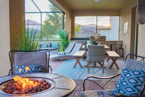A patio area with outdoor furniture, a fire pit, and a view of the landscape. - Sleeps 21 / Disney & Universal Retreat w/ Game Room + Pool, Spa (Kissimmee)