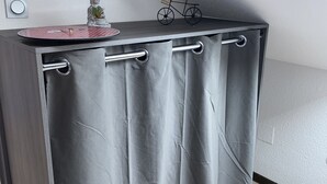 A modern kitchenette with a grey curtain, a small Buddha statue, a potted plant, and a miniature bicycle on the countertop. - At Léa's cozy little nest (Muhlbach)