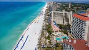 A coastal hotel with a beach view, multiple swimming pools, and a large number of beach umbrellas. - Stunning Gulf views, 2BR Corner Unit, at Tops'l resort! (Miramar Beach)