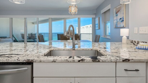 A modern kitchen with a marble countertop, stainless steel sink, and pendant lights. - Stunning Gulf views, 2BR Corner Unit, at Tops'l resort! (Miramar Beach)