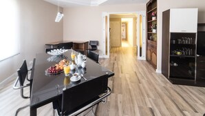 Une cuisine moderne avec une table à manger noire, un coin café et un plancher en bois.