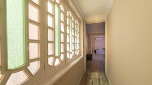 Un couloir avec un plancher en bois et un mur blanc.