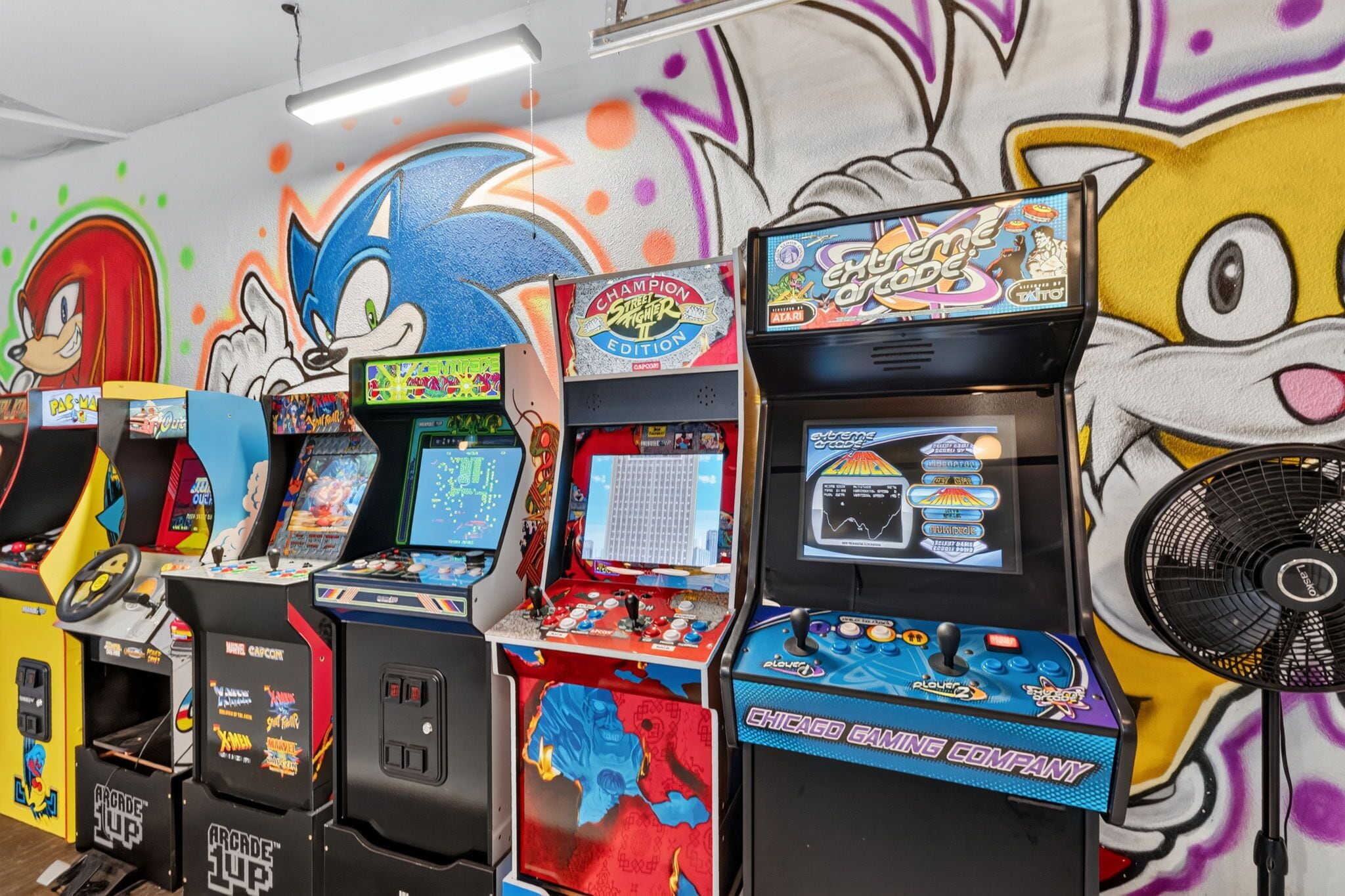 A row of arcade gaming machines with various colorful graphics and characters.