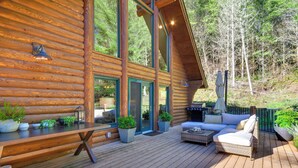 A log cabin with a deck, outdoor seating, and a view of the forest. - Luxe Cabin in the Woods: Walk to Lake! (Gaston)