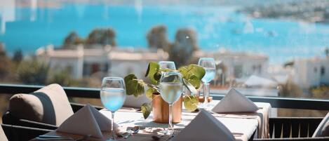 Mesa lista para comer con vista al mar y a las montañas.