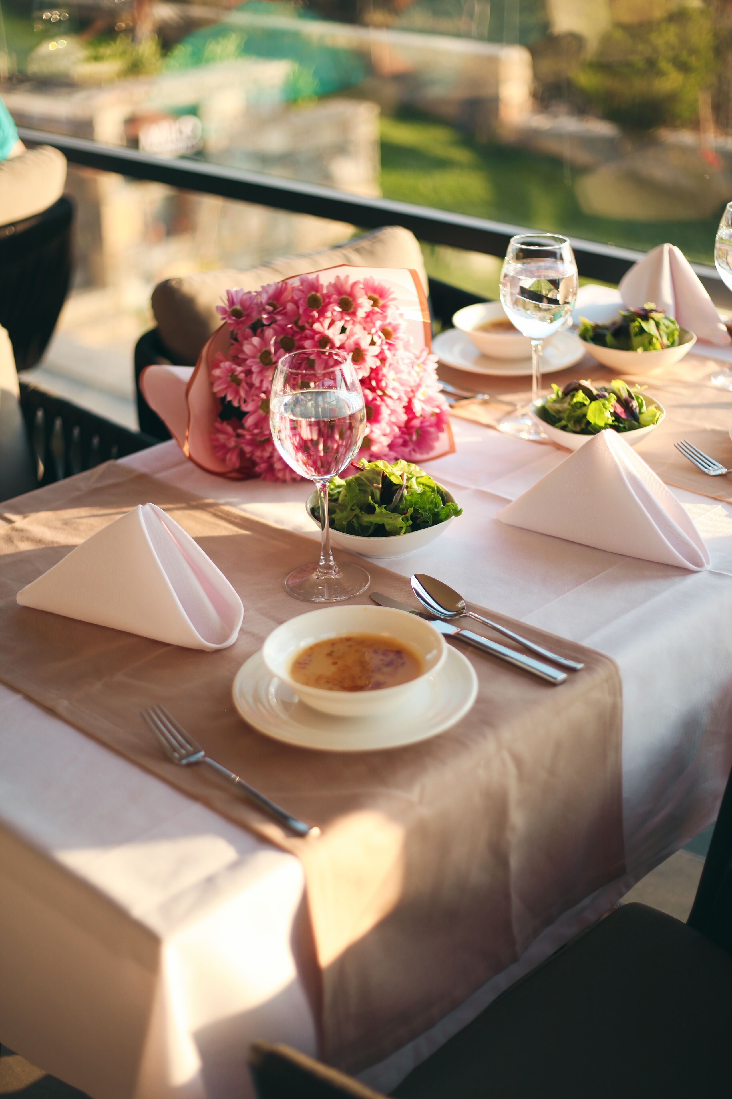 Una mesa lista para una comida, con vistas al exterior.