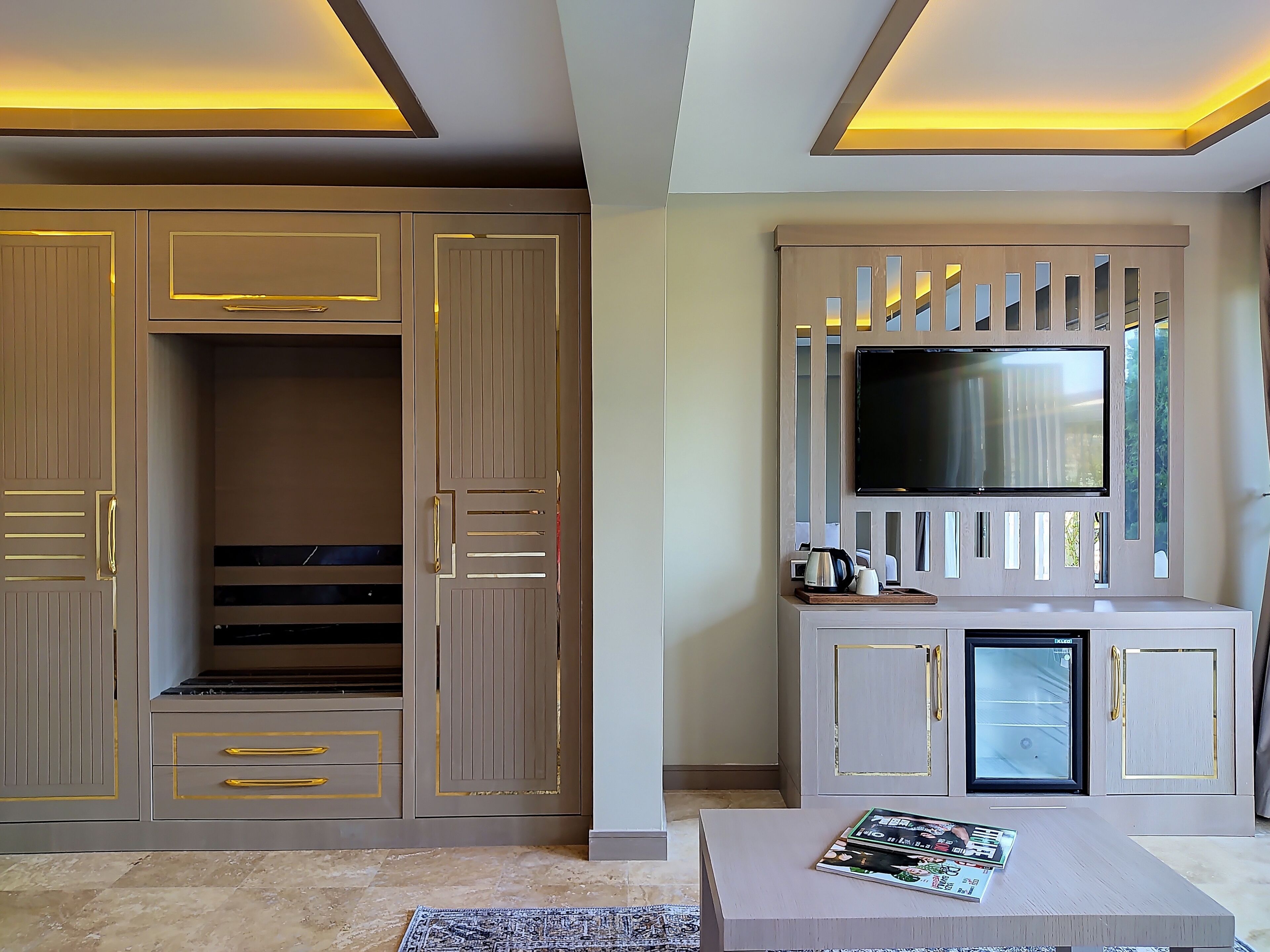 Una sala de estar moderna con un mueble de entretenimiento grande, televisor integrado y una mesa de centro.