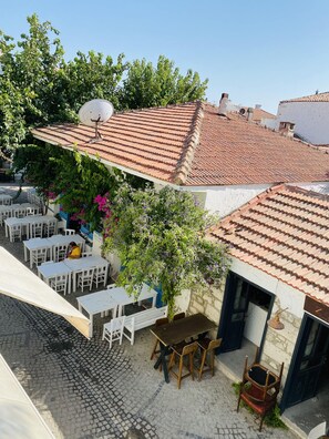 A courtyard with outdoor seating, a satellite dish, and a cobblestone floor. - Alaca Butik Otel (Cesme)