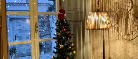 A cozy room with a Christmas tree, gifts, and a lamp.