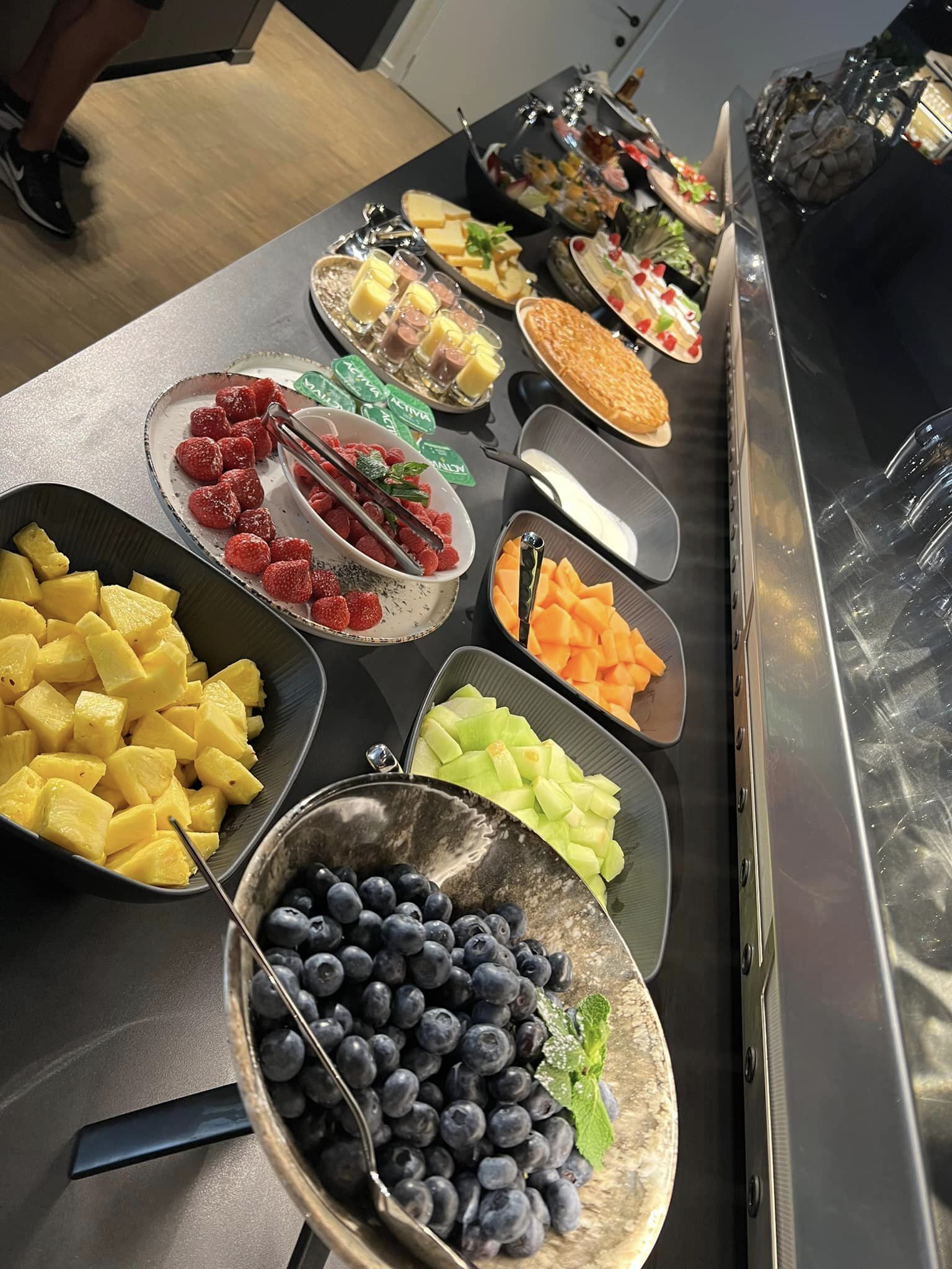 A buffet with various fruits and desserts.