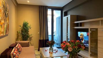 Suite Deluxe, 2 camas Queen size | Área de sala de estar | Smart TV de 48 pulgadas con canales vía satélite y Netflix