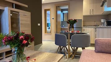 Suite Deluxe, 2 camas Queen size | Área de sala de estar | Smart TV de 48 pulgadas con canales vía satélite y Netflix