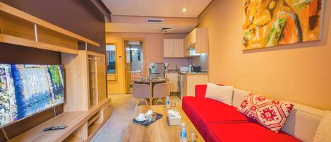 A compact living space with a red sofa, a dining area, and a kitchen.