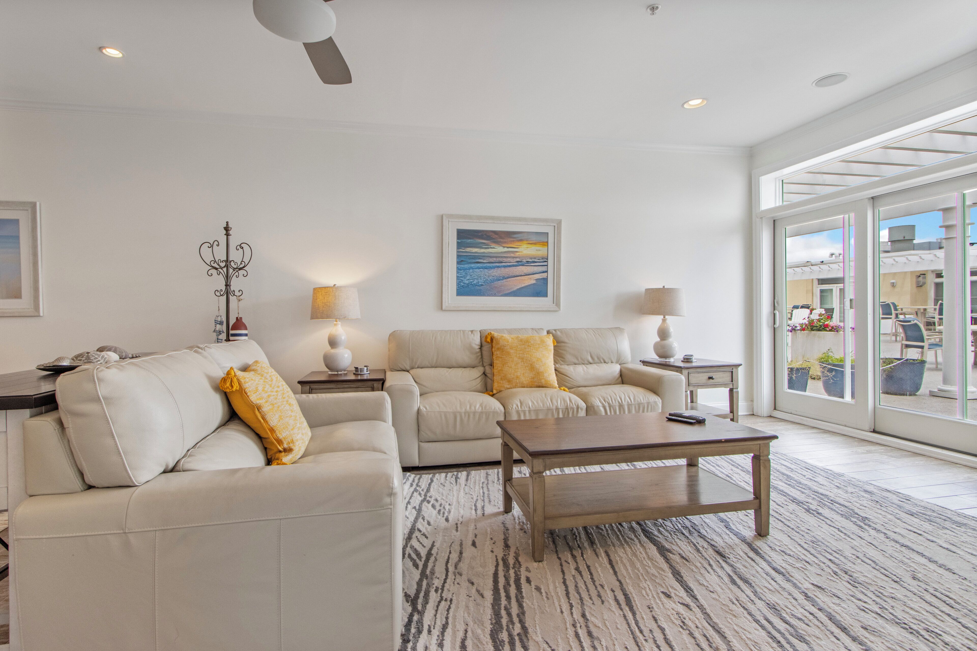 A modern living room with a sofa, coffee table, and a painting on the wall.