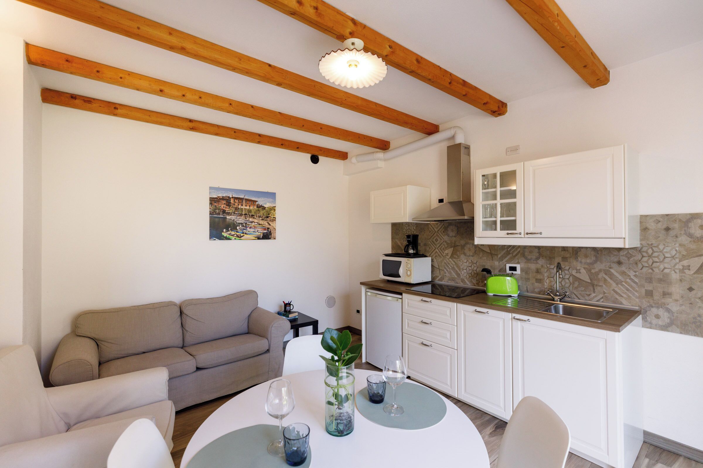 A compact living space with a kitchenette, a dining area, and a sofa.