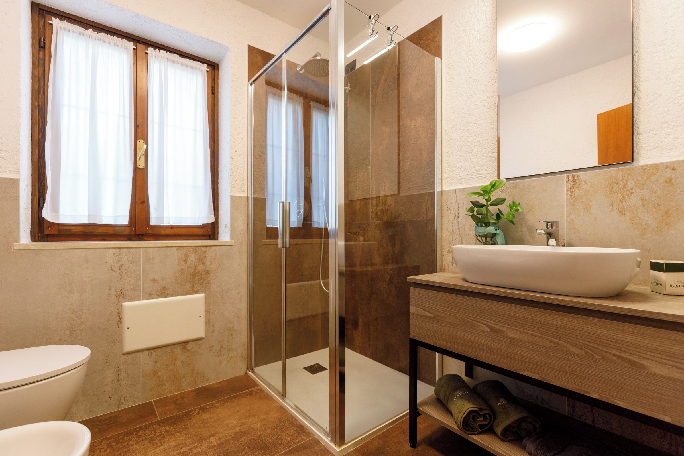 Une salle de bain avec une douche à parois de verre, un lavabo et des toilettes.
