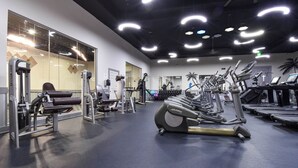 A gym with exercise equipment, a mirrored wall, and a ceiling with circular lights. - Gorgeous 12th Floor Views at The Palms of Destin! (Destin)