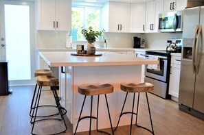 Enjoy cooking in this well-lit kitchen with a large island and stainless steel appliances.