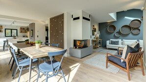 A modern living space with a dining area, kitchen, and seating area.