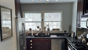 A modern kitchen with a refrigerator, stove, and double sink. - 1.5 miles to Mount Snow ski resort and minutes to area golf courses . (Dover)
