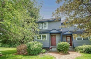 Stunning two-story home with a central entrance and beautifully manicured lawn.