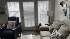 A living room with a sofa, a chair, a coffee table, and a door with three windows. - 1.5 miles to Mount Snow ski resort and minutes to area golf courses . (Dover)