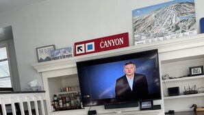 A living room with a television, a fireplace, and a sign that reads "CANYON". - 1.5 miles to Mount Snow ski resort and minutes to area golf courses . (Dover)