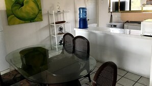 Eine kompakte Küche mit Essbereich, Wasserspender und Deckenventilator.