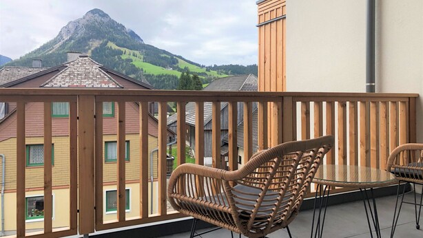 A balcony with wicker chairs and a view of a mountain. - Alm Lodge A8 - Tauplitz Lodges (Tauplitz)