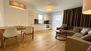 A modern apartment with a dining area, kitchen, and living room. - Alm Lodge A8 - Tauplitz Lodges (Tauplitz)