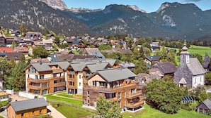 Une station de montagne avec des bâtiments en bois, une église et une vue sur des montagnes enneigées.