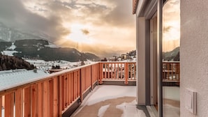 A balcony with a wooden railing overlooking a snowy landscape with mountains in the background. - Bergblick Lodge B6 - Tauplitz Lodges (Tauplitz)