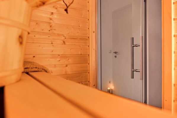 A wooden interior with a door and a small light on the floor.