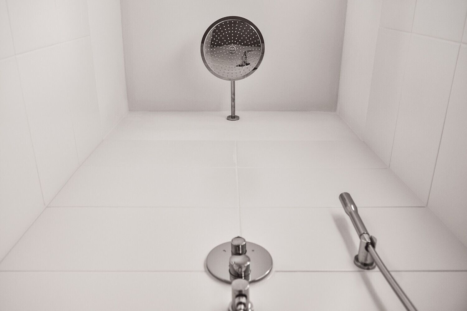 Ein Badezimmer mit Dusche, Duschbrause und Handspiegel.