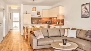 Un apartament modern amb saló, zona de menjador i cuina.