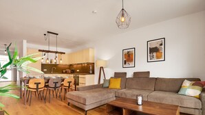 Una sala de estar moderna con sofá, mesa de centro y comedor.