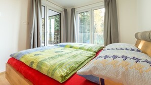 Un dormitorio con dos camas, ventanas amplias y vistas al exterior.