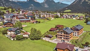 A mountainous village with traditional wooden houses, a central church, and a large building with a balcony. - Panorama Lodge Alpine Living 201 (Tauplitz)