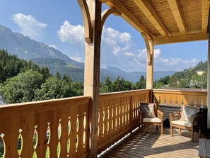 Eine Holzterrasse mit Blick auf Berge und Bäume.