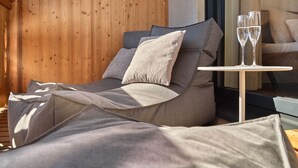 Une chambre à coucher moderne avec un lit, des oreillers et une petite table sur laquelle sont posés deux verres.