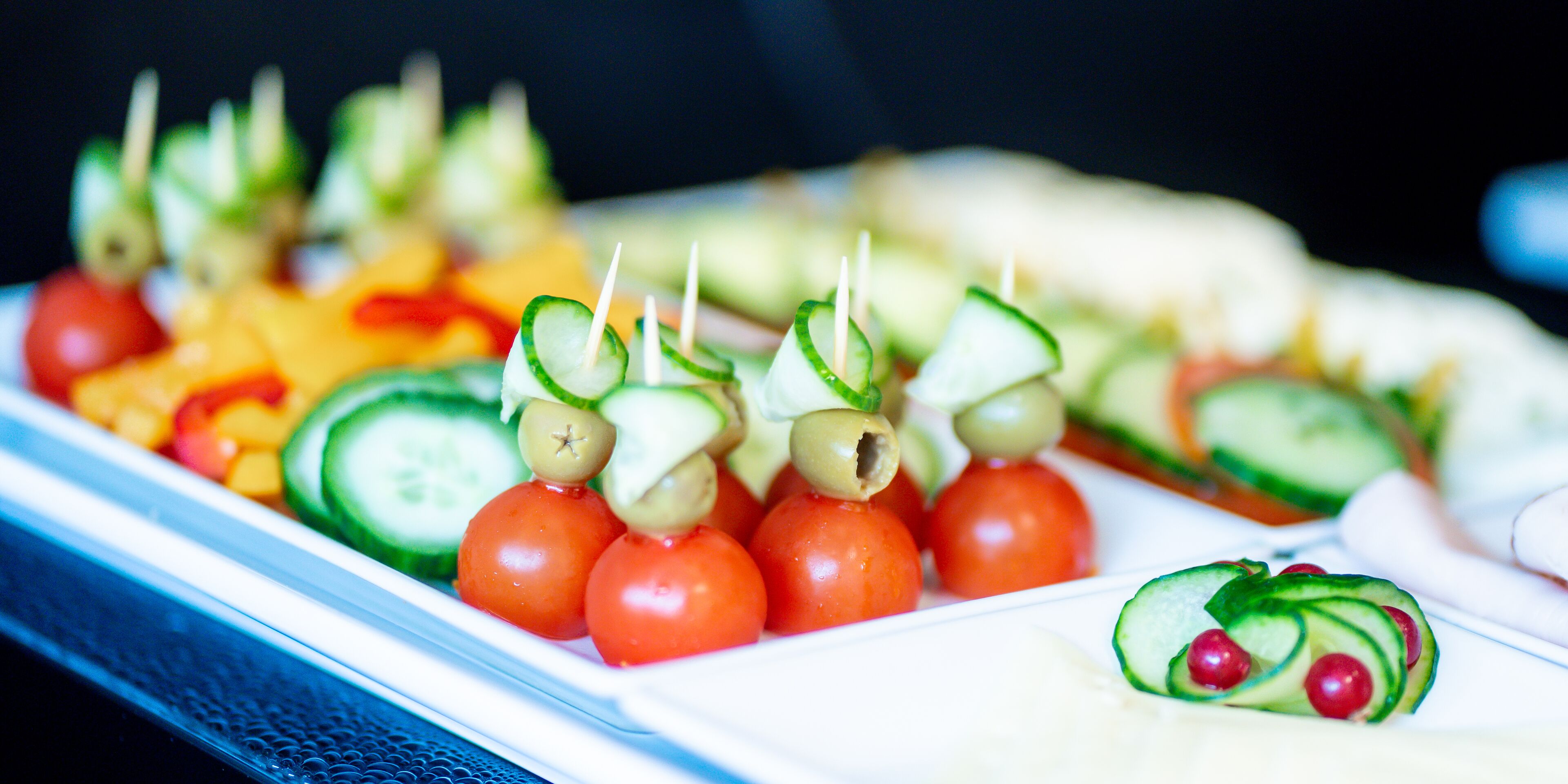 Brochetas de vegetales frescos sobre un plato blanco.