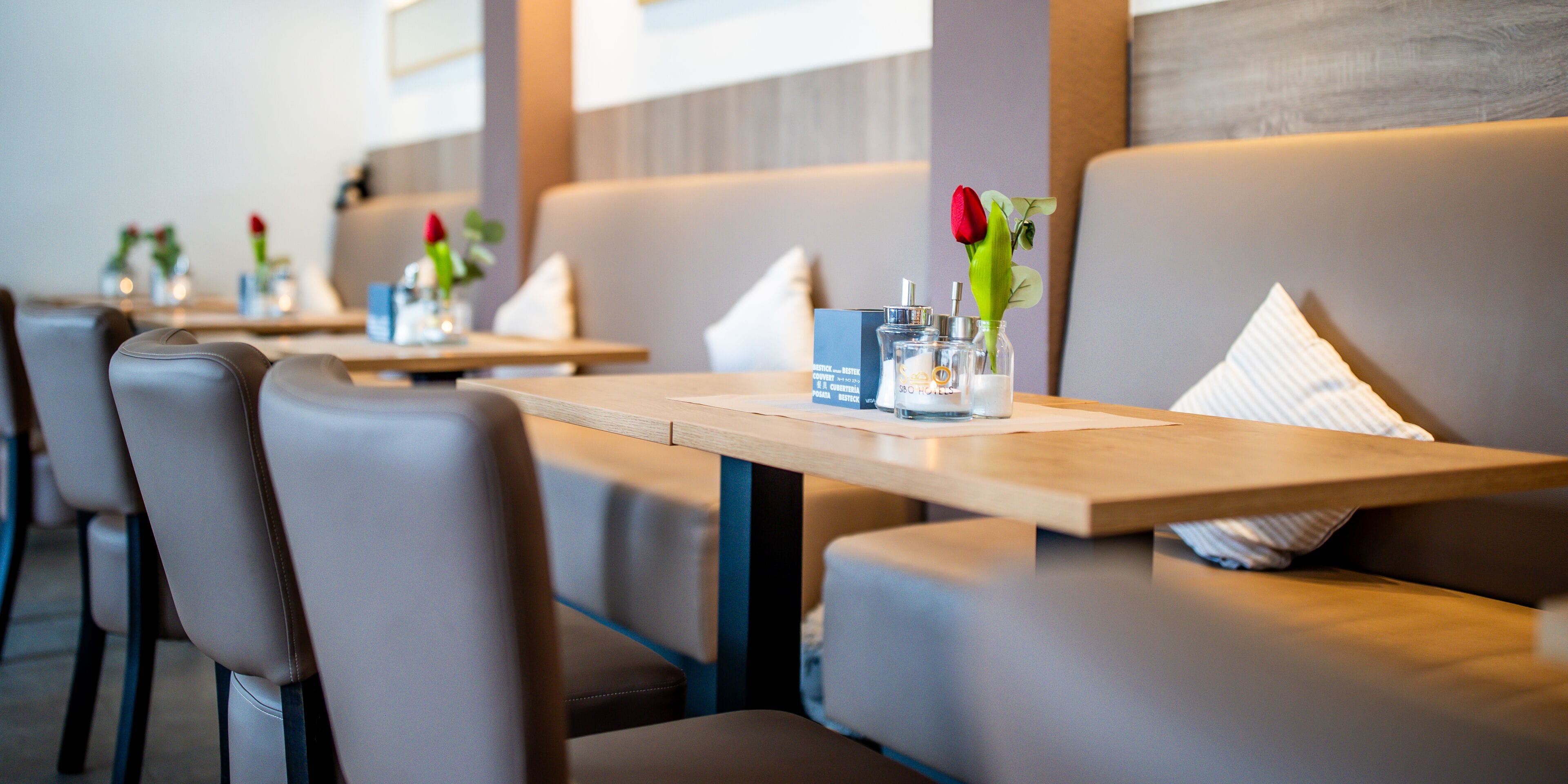 A modern restaurant with booth seating and a clean, minimalist design.
