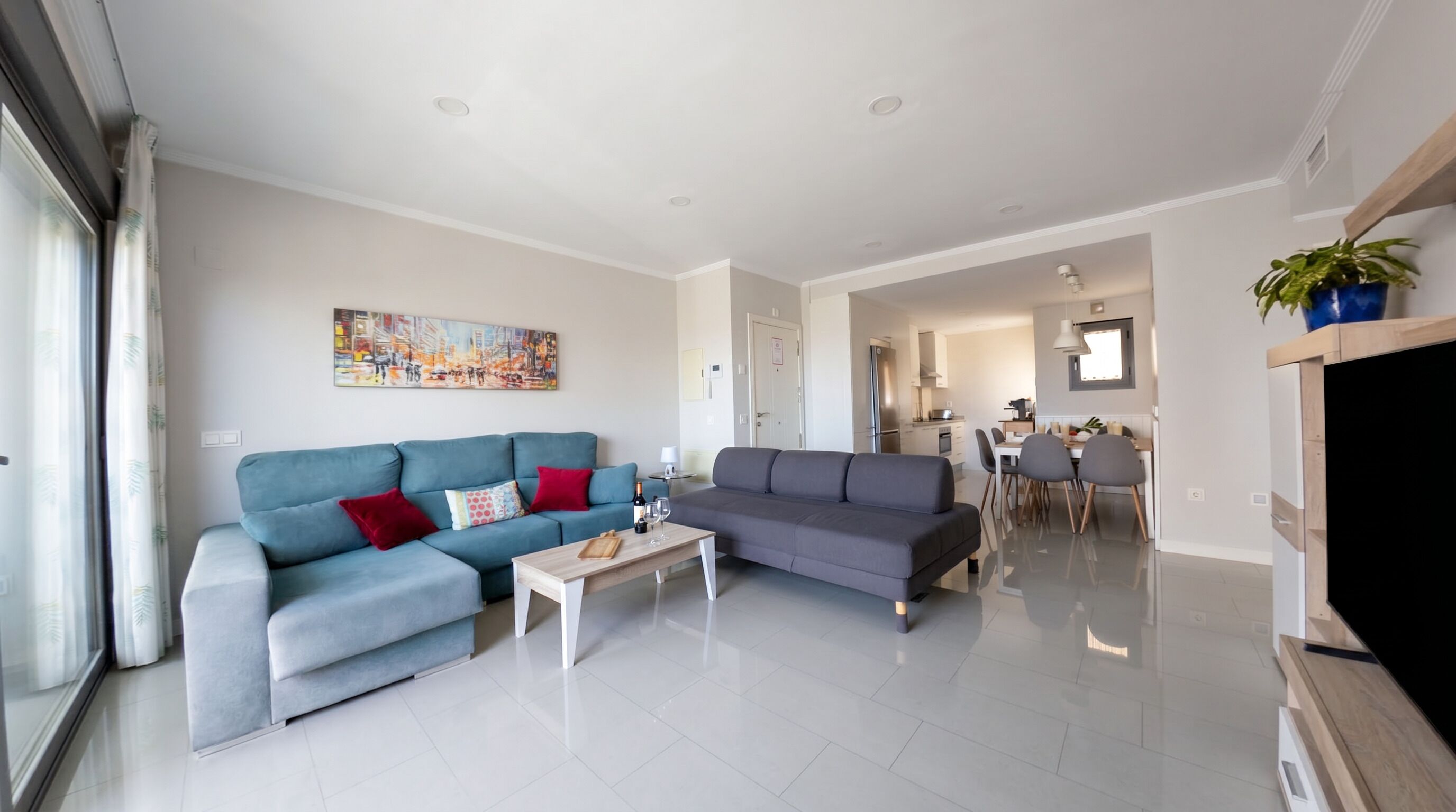 A modern living room with two sofas, a coffee table, and a dining area with chairs and a table.