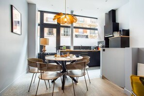 A modern kitchen with a round dining table, wicker chairs, and a pendant light. - Appart indépendant, 2chambres!Parc des expositions (Paris)