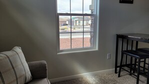 A room with a window, a couch, a small table, and a chair. - CASITA NEAR ZION (Hurricane)