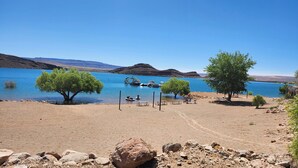 A lakeside area with picnic tables, a boat dock, and a tree. - CASITA NEAR ZION (Hurricane)
