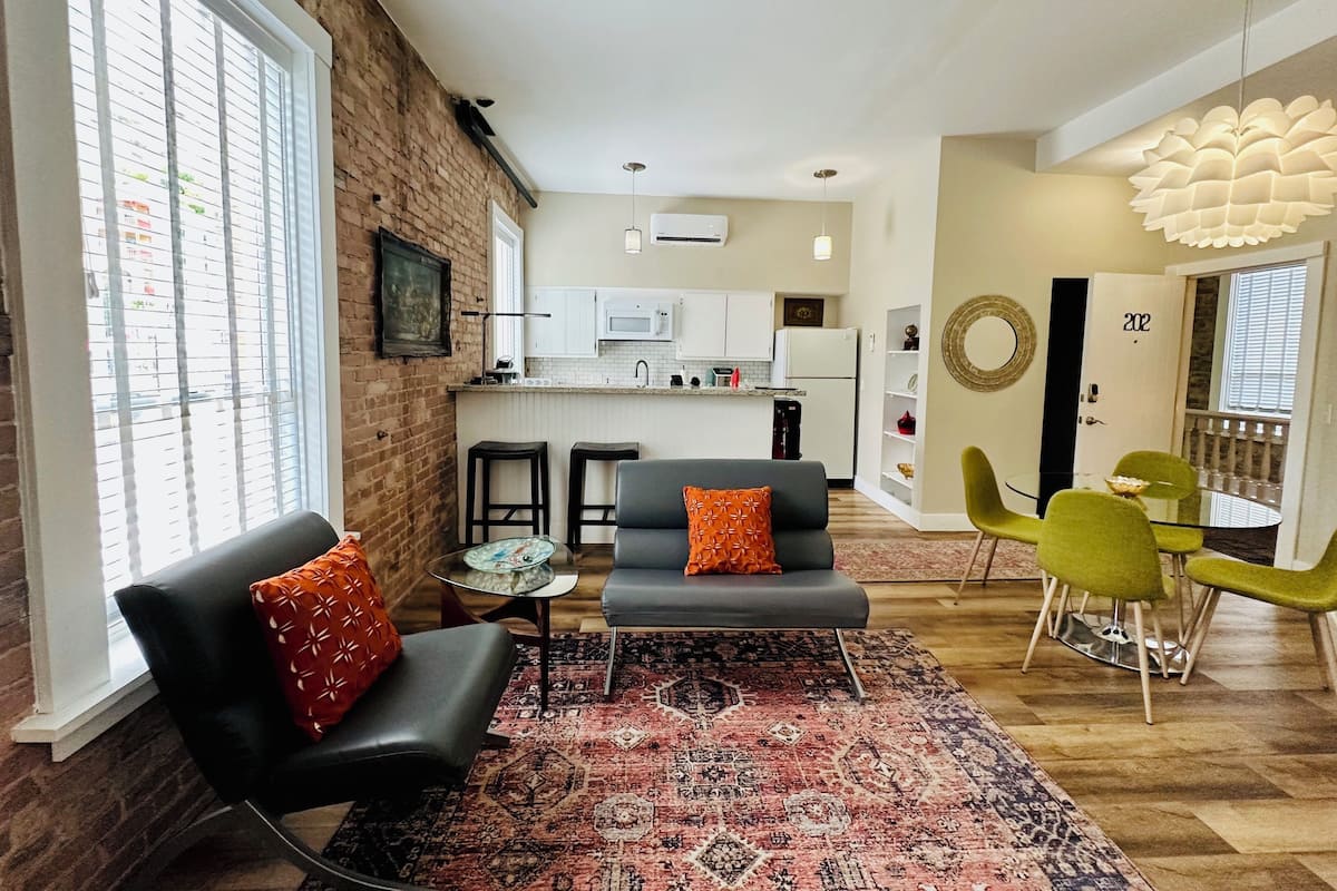 A modern apartment with a living room, dining area, and kitchen.