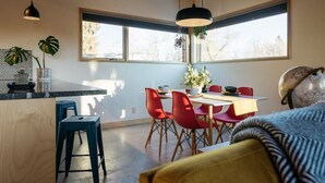 Una cocina moderna con comedor, ventanas amplias y un globo en la pared.