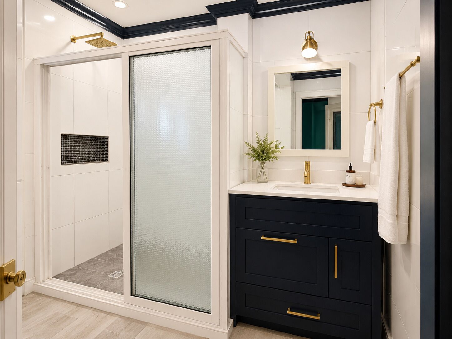 A modern bathroom with a walk-in shower, a vanity with a mirror, and a small plant on the counter.