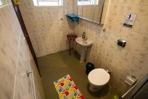 Een kleine badkamer met toilet, wastafel en spiegel.